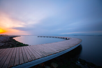 The pier like a boomerang at sunrise was captured with the long exposure technique.