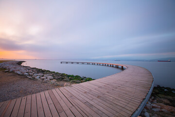 The pier like a boomerang at sunrise was captured with the long exposure technique.