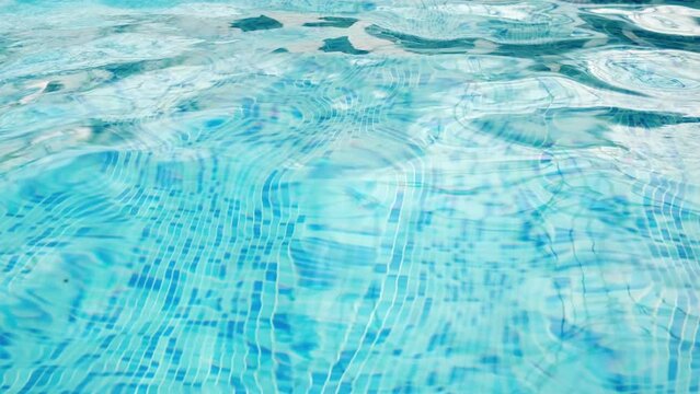Clear blue waves on the surface of the swimming pool. The concept of summer holidays, pool cleaning