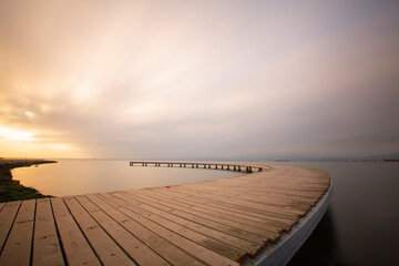 The pier like a boomerang at sunrise was captured with the long exposure technique.