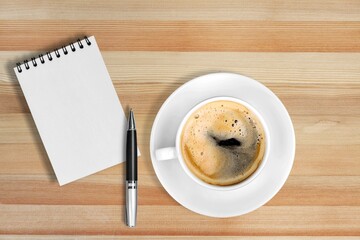 Coffee cup, notebook on wooden table