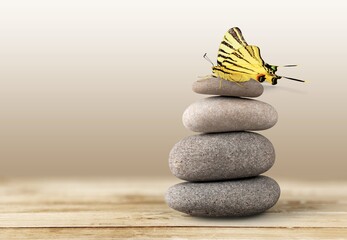 Fototapeta na wymiar Life Concept. Butterfly on the Stone Stack. Balancing Nature and Technology concept.