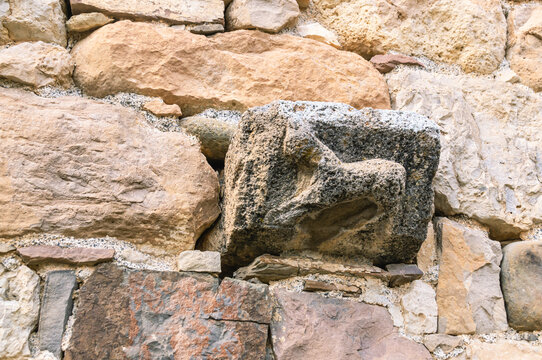 Background of the masonry of an ancient temple. Place of religious ceremonies. An ancient stone wall with images that have undergone devastating erosion.