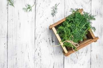 Bunch of dill in wooden box light background. Food for vegetarians. Long banner format. top view