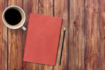Obraz na płótnie Canvas Red notebook with pencil and coffee cup on marble texture. Top view