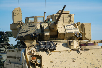 Military or army tank ready to attack and moving over a deserted battle field terrain. 