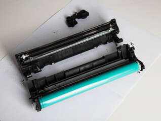 Disassembly of the printer cartridge for its maintenance and refilling with toner. White background, technology