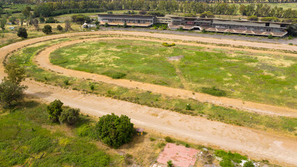 Fototapeta na wymiar Aerial view of the hippodrome of Tor di Valle in Rome, Italy. This stadium was an important horse racing venue and included a racetrack, a training track and right track. Now it's closed and abandoned