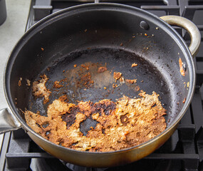 Burnt food in a pan of poor quality. Frying pan with non-stick coating, close-up
