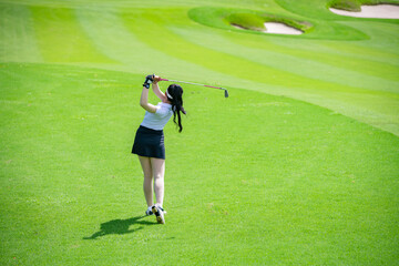 Professional woman golfer teeing golf in golf tournament competition at golf course for winner