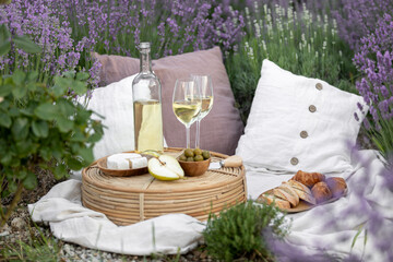 Glass of white wine in a lavender field. Violet flowers on the background.