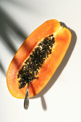 Papaya on a white background with palm leaf shadow