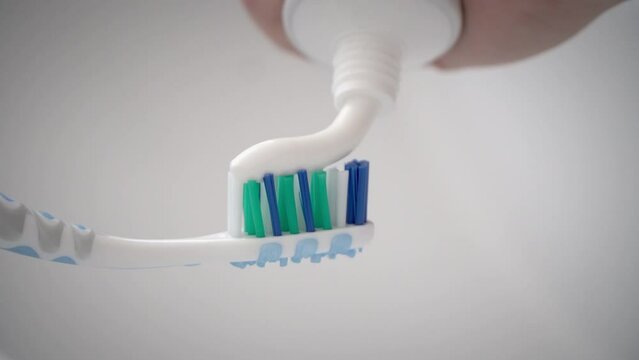 Macro shot of toothpaste applied to toothbrush