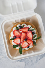 Honey bento cake decorated with cream and fresh strawberries and blueberries.