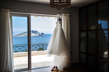 Wedding dress hanging on the window in the room