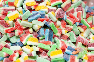 Candy sweets jelly. Close up view of delicious sweet candies in form of fruit slices. Fruit jelly in shop window. Sweets for Easter, Halloween. Unhealthy or organic food. Selective focus. Top view 