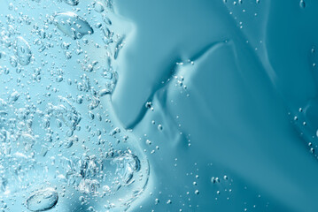 Close up macro Aloe vera gel cosmetic texture blue background with bubbles. Lemongrass gel skincare...