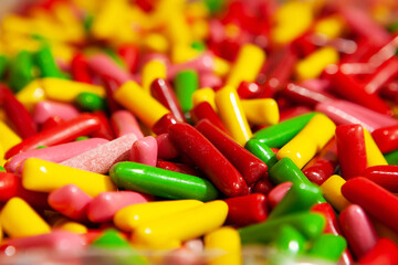 Candy jelly sweets. Close up view of delicious sweet candies in form of sticks. Fruit jelly in shop window. Sweets for Easter, Halloween, candy for sale. Unhealthy or organic food. Selective focus 