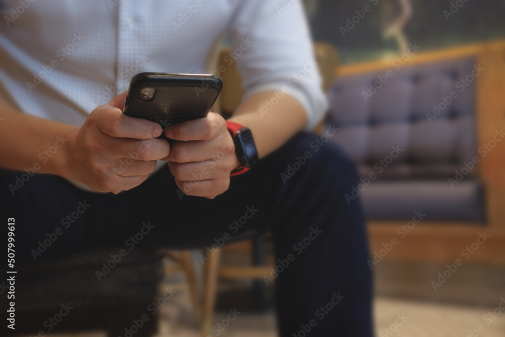 Poster business man using smartphone application to communicate with colleague while sitting inside cafe. d