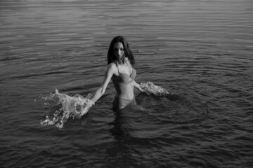 Fototapeta premium Young long-haired woman in bikini in the lake in black and white