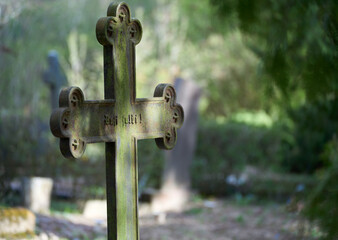 Ancient metal cross in the Latvian cemetery. Sunny day.