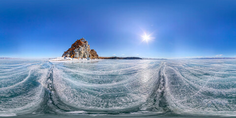 Spherical Panorama 360 degree Shaman Rock or Cape Burhan on Olkhon Island in winter, surrounded by the blue ice of Lake Baikal with cracks.