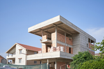 Construction of a modern house made of reinforced concrete with a flat roof