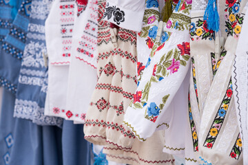 Closeup view of ethnic ukrainian traditional embroidered men and women shirts, vyshyvanka - traditional embroidered clothing on flea market or national festival. Symbol of Ukrainian culture