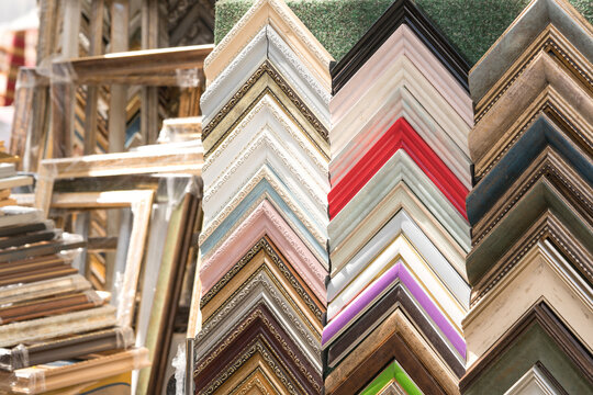 Various wooden and plastic picture frames in different colours and sizes as background with copy space. Custom picture and arts framing service
