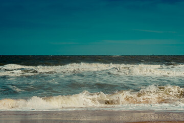 Ocean storm waves dramatically crashing splashing. Sky horizon line. Sea water edge, nature front view marine wallpaper. Bad weather cloudy overcast. Dark green turquoise blue bright vivid contrast