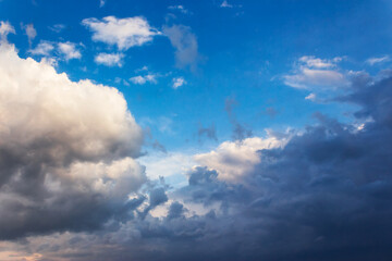 Obraz premium white cumulus clouds on a blue sky. beautiful nature background in evening light
