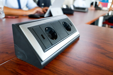 Station with electrical outlets on a desk in a work room.