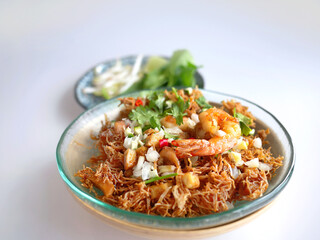 Thai Crispy rice noodles in traditional style with shrimp, Royal recipe, in special plate and vegetable with copy space and white background