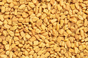 Background from spice Fenugreek. Macro. Flat lay. Vegetarian food concept