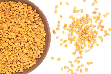 Fenugreek (Trigonella foenum-graecum) in clay plate and bunch on white background isolated. Macro. Flat lay. Indian cuisine, ayurveda, naturopathy concept