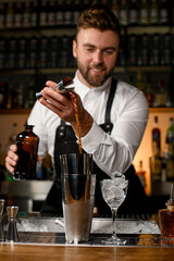 beautiful view of shaker cups on bar counters in which the bartender pours a drink
