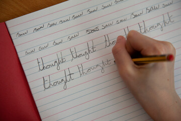 Close up of a childs hand practicing handwriting in school