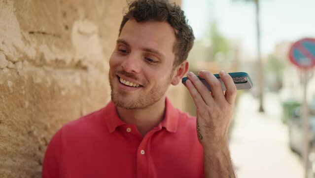 Young hispanic man smiling confident listening audio message by the smartphone at street