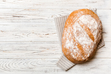 Freshly baked delicious french bread with napkin on rustic table top view. Healthy white bread loaf