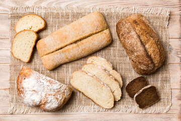 Freshly baked bread slices on napkin against natural background. top view Sliced bread