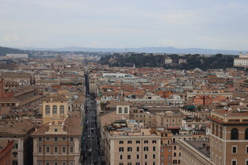 ROME, ITALY - February 05, 2022: Panoramic view around the Colosseum in city of Rome, Italy. Cold and gray sky in the background. Macro photography of the green parks with the old buildings.