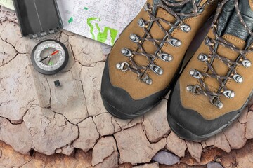 Fototapeta na wymiar Hiking sport boots on the desk with travel tools