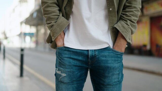 Young hispanic man showing empty pockets at street