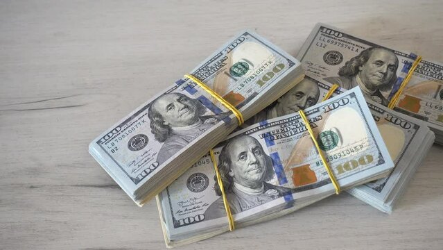 4K view of stacks of dollar bills  on the table.