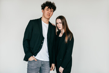 Young attractive couple of confident partners. businesspeople in black clothes standing together, touching each other
