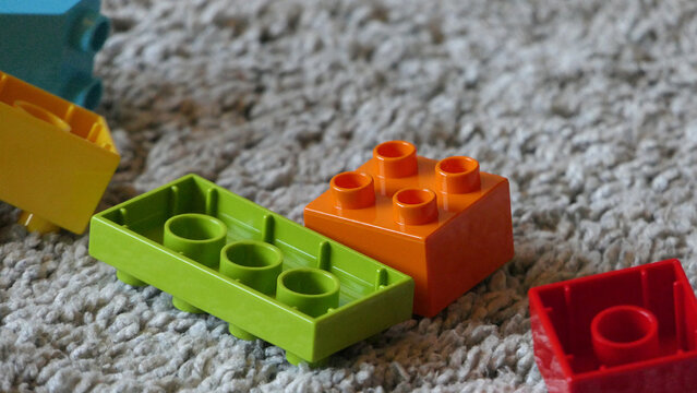 Mix of Colourful Pieces of Lego sitting on mat indoors