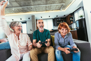 Group of middle age friends smiling happy playing video game at home. © Mediteraneo