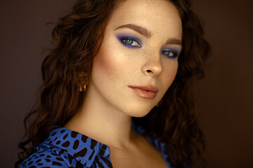 Red-haired girl with freckles. Blue makeup.