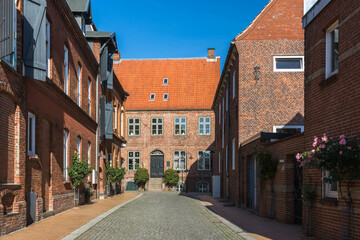 Fototapeta na wymiar Street with red brick buildings in Husum, North Frisia, Schleswig-Holstein, Germany