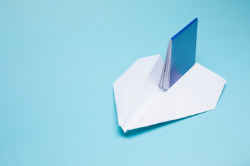  Paper plane and international passport on blue background. Travel concept.